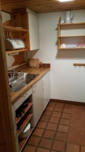 a small kitchen with white cabinets and a sink at Gibelhüüs 2-Bettwohnung - b48627 in Hasliberg Wasserwendi