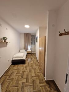 Habitación con cama y pasillo con suelo de madera. en Zajazd Polonia en Kędzierzyn-Koźle