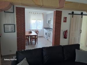 a living room with a couch and a kitchen with a table at Dulce hogar in Miengo +12 photos