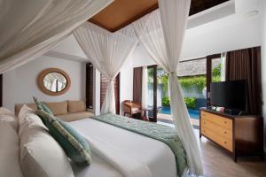 a bedroom with a large bed and a television in it at Lembongan Beach Club & Resort in Nusa Lembongan