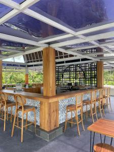 um bar com bancos e mesas e cadeiras de madeira em Manca Kemetug em Blimbing