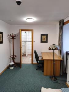an office with a desk and a table with a lamp at Apartament dla dwóch osób - Piotrkowska 262-264 pok A101 in Łódź