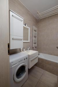 een badkamer met een wasmachine en een wastafel bij Apartament Słoneczny 10 in Opole