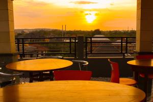 un patio con tavoli e sedie con un tramonto sullo sfondo di Ramantika Bali House a Jimbaran