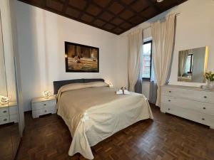 a bedroom with a large bed and two windows at Villanova d'Asti Charming House with barbecue by Alterego in Villanova dʼAsti