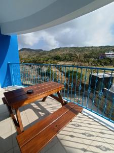 a wooden bench sitting on a balcony overlooking the ocean at 迦那會館 in Eluan