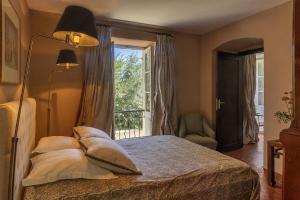 1 dormitorio con cama con almohadas y ventana en Villa les Roses, en Brando