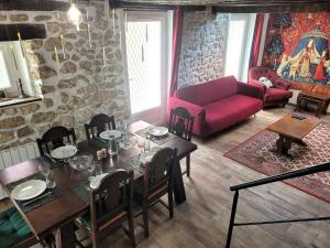 ein Wohnzimmer mit einem Tisch und einer roten Couch in der Unterkunft La demeure des maraudeurs -10min Disney-Jardin & BBQ in Villiers-sur-Morin
