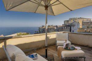a balcony with two chairs and an umbrella at Villa la Rose des Mers in Brando