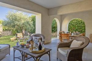 un patio esterno con tavolo e sedie in vimini di Villa la Rose des Mers a Brando