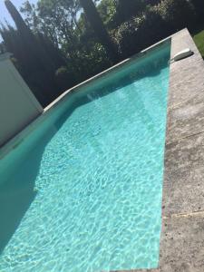 een zwembad met blauw water in een tuin bij Loft 52 in Aix-en-Provence