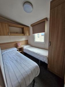 a small room with two beds and a window at 107 Arran View with WiFi in Ayr