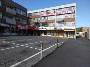 um parque de estacionamento vazio em frente a um edifício em Queen's Place em Joanesburgo