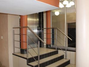 a metal staircase in a building with orange columns at Queen's Place in Johannesburg