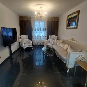 a living room with a couch and chairs and a television at Butthouse Apartments in Trimbach