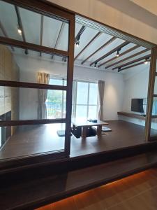 a living room with a large window and a table at 迦那會館 in Eluan
