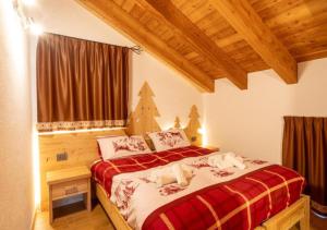 a bedroom with a bed with red and white sheets at Baita Stabli-Rifugio Luxury a 1700 mt in Mezzana