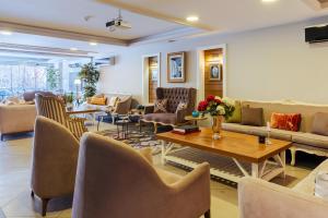 a living room with couches and a table and chairs at Cheya Beşiktaş Istanbul Bosphorus City Center Hotel & Suites in Istanbul