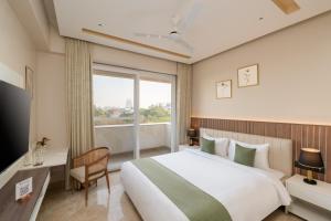 a hotel room with a large bed and a window at Foxtrail, Sector 42 - AM Hotel Kollection in Gurgaon