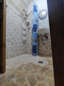 La salle de bains est pourvue d'une douche et d'un lavabo. dans l'établissement Kryptàdion, à Grottaglie