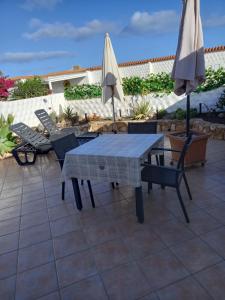 - une table, des chaises et un parasol sur la terrasse dans l'établissement casa yamila, à Costa Calma