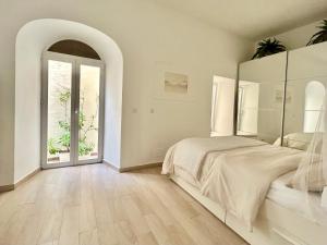 um quarto branco com uma cama e uma porta arqueada em Duna em Tarifa