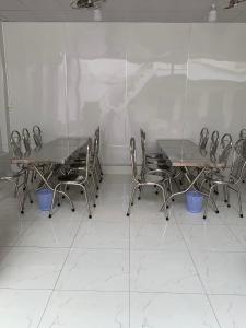 eine Gruppe von Tischen und Stühlen in einem Zimmer in der Unterkunft Nhà Trọ Số 2 in áº¤p VÄ©nh ÃÃ´ng