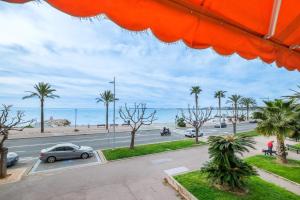 a view of a street with palm trees and the ocean at Angelina - La002 in Cagnes-sur-Mer