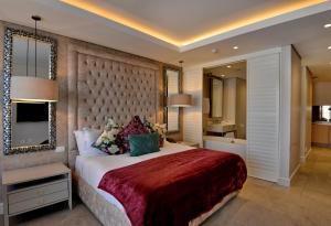 a bedroom with a large bed and a bathroom at Houghton Suites in Johannesburg