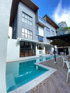 a house with a swimming pool in front of it at Acacia Garden Inn in Coron