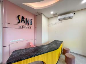 a dressing room with a bench and a sms motel sign at SANS Hotel Premiere Majapahit Semarang in Semarang