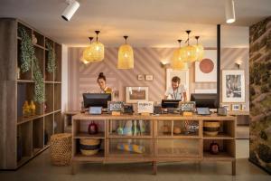 two people working at a counter in a store at HVAR PLACESHOTEL by Valamar in Stari Grad