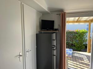 a room with a television and a door to a patio at CHEZ PHIL in Gastes