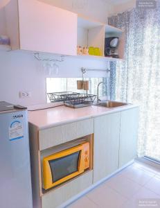 a small kitchen with a microwave and a sink at Rooms hua hin nearby the beach in Hua Hin