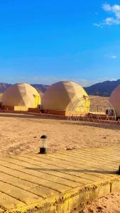duas cúpulas no deserto com montanhas ao fundo em RAMA CAMP wadi rum em Disah