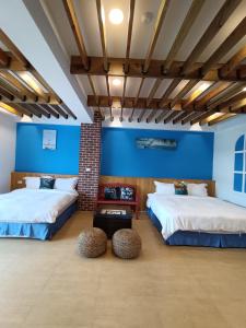 2 camas en una habitación con paredes azules en 迦那會館, en Eluan