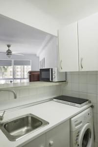 - une cuisine blanche avec évier et four micro-ondes dans l'établissement Algarrobo Costa piscina sol y playa, à Algarrobo-Costa