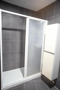 La salle de bains est pourvue d'une douche avec une porte coulissante en verre. dans l'établissement Algarrobo Costa piscina sol y playa, à Algarrobo-Costa