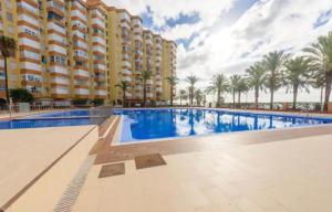 une piscine avec des palmiers en arrière-plan dans l'établissement Algarrobo Costa piscina sol y playa, à Algarrobo-Costa