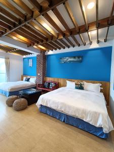 鵝鑾的住宿－迦那會館，蓝色墙壁客房的两张床