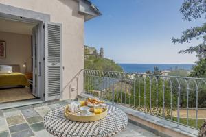a table on a balcony with a view of the ocean at Villa Cintolino in Brando
