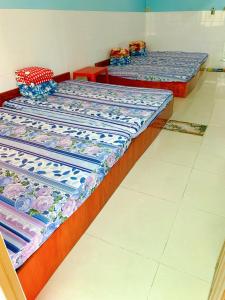 três camas estão alinhadas num quarto em Nhà Trọ Số 2 em áº¤p VÄ©nh ÃÃ´ng