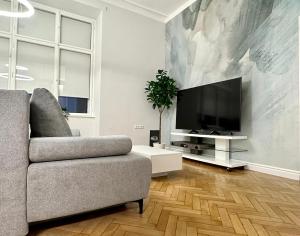 a living room with a couch and a flat screen tv at Stylish Apartment - in the Center in Vienna