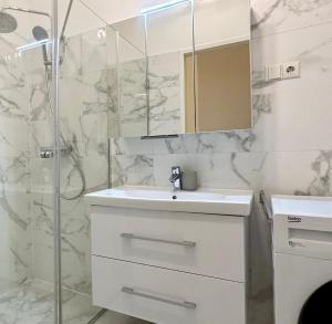 een witte badkamer met een wastafel en een douche bij Stylish Apartment - in the Center in Wenen