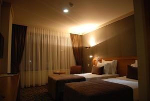 Pokój hotelowy z 2 łóżkami i krzesłem w obiekcie Volley Hotel İzmir w mieście Konak