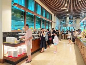 a group of people standing at a buffet in a restaurant at Sokha Siem Reap Resort & Convention Center in Siem Reap