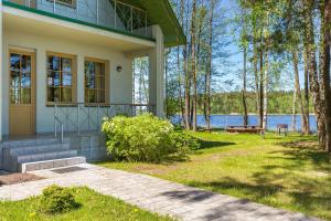 ein Haus am Ufer eines Sees in der Unterkunft Pussala in Daugavpils