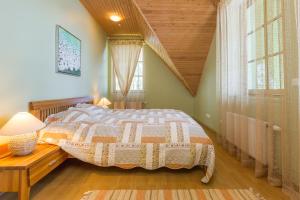 een slaapkamer met een bed en een houten plafond bij Pussala in Daugavpils