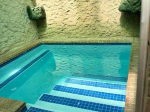 a swimming pool with blue tiles in a stone wall at Dula Monate Holiday Flats in Bela-Bela