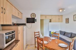 een keuken en eetkamer met een tafel en een bank bij Le "Pépère" charming apartment 150m from the beach in Sète